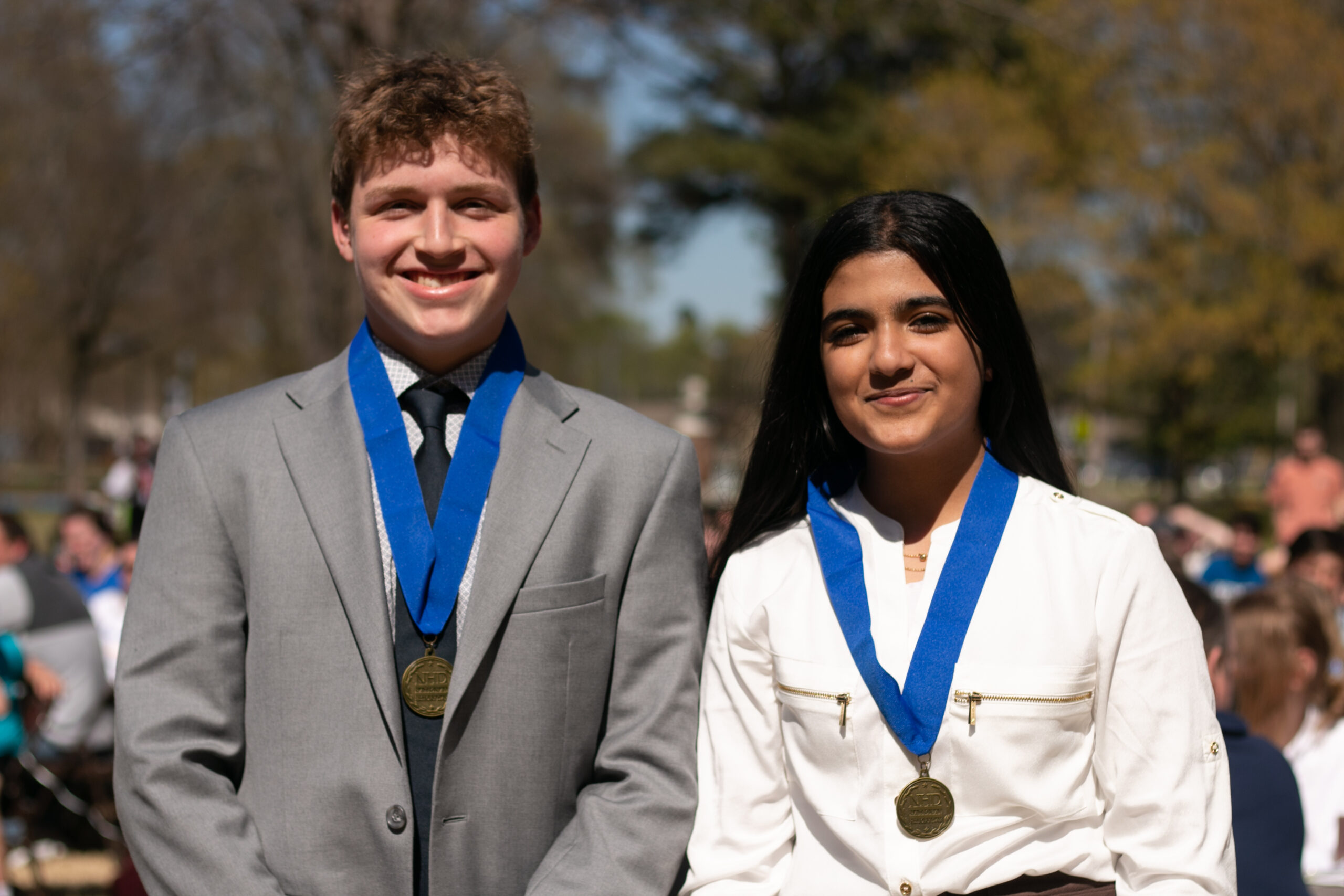 Two students pose for a picture wearing first-place medals